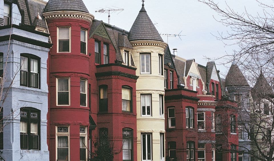 downtown-georgetown | Hideaways Beach Resort Exuma, GeorgeTown Vacation Rentals Row of colorful Victorian townhouses with rounded turret bays along a tree-lined street.
